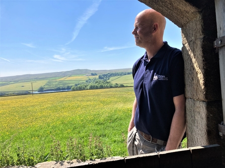Mark Dinning pictured through barn door looking out over Hannah's Meadow