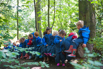 Children from school visit sitting on logs