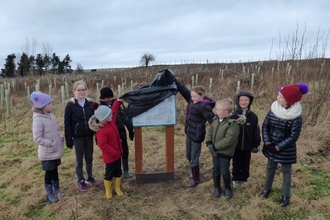 Pupils from Tow Law Millennium School reveal the new interpretation panel at Thornley Wood.