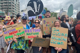 group of people holding placards with nature messages on them