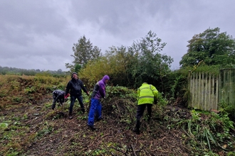 four people doing conservation work in church grounds