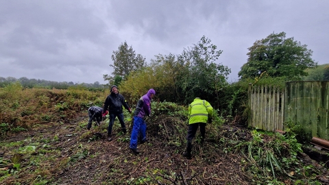 four people doing conservation work in church grounds