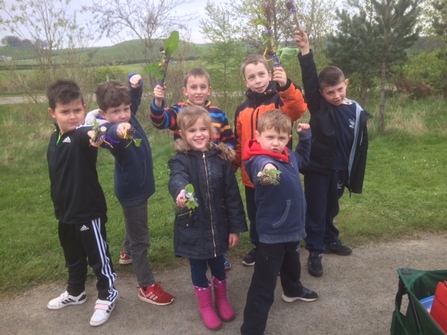 Children holding out their nature finds on a school visit with the Trust