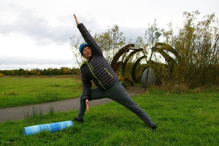 Roy Moor, yoga instructor, demonstrating a pose on grass