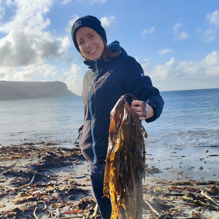 Martina Bristow on a beach holding kelp