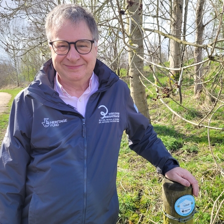 Paul Black standing at walking route marker post