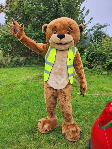 A person in otter costume waving at camera