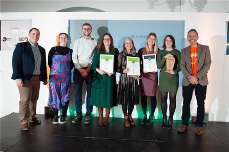 a group of people holding certificates on a stage