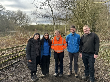 Group of people standing on path next to wetland